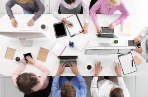 Picture of a group of students sitting working at a table viewed from above.